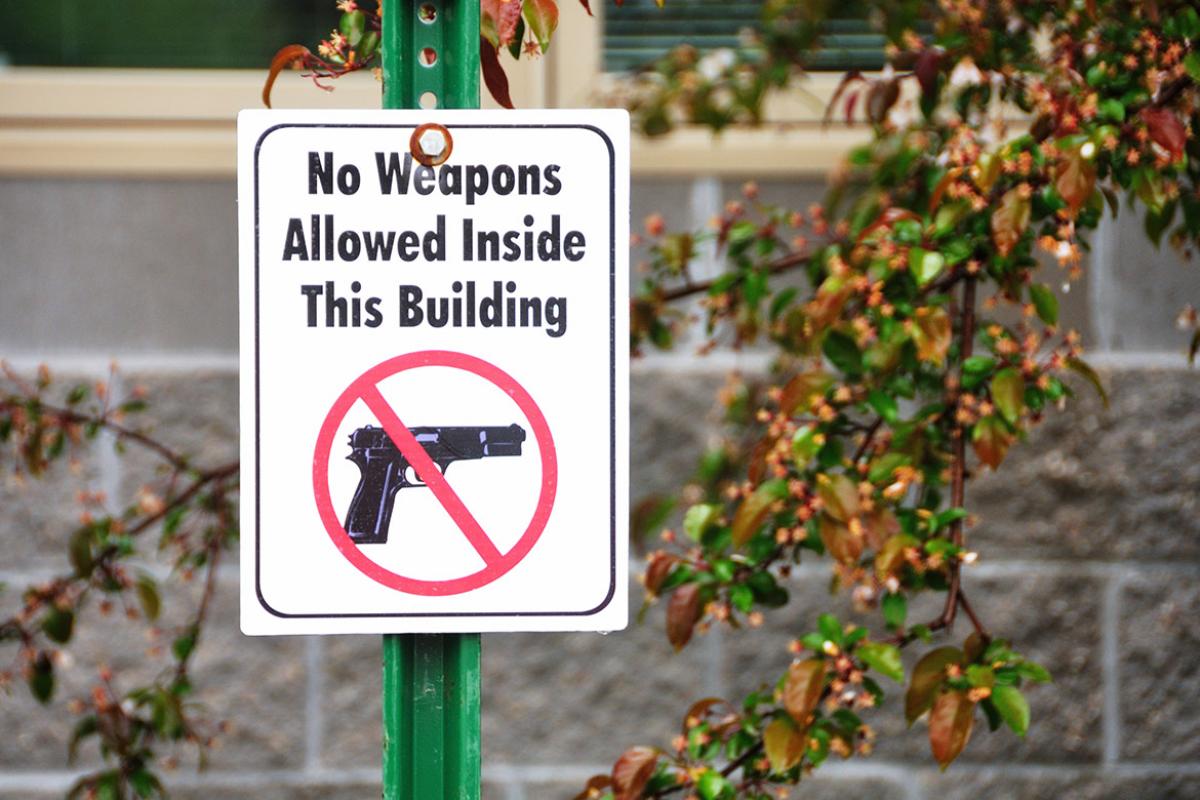 "No weapons" and "no guns" sign placed on a post