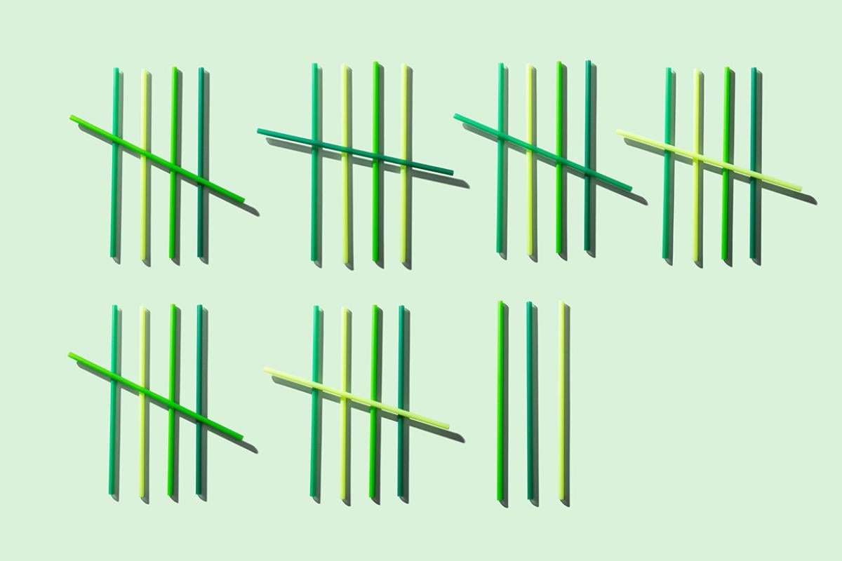 Green, blue and yellow straws lined up in groups of five for counting