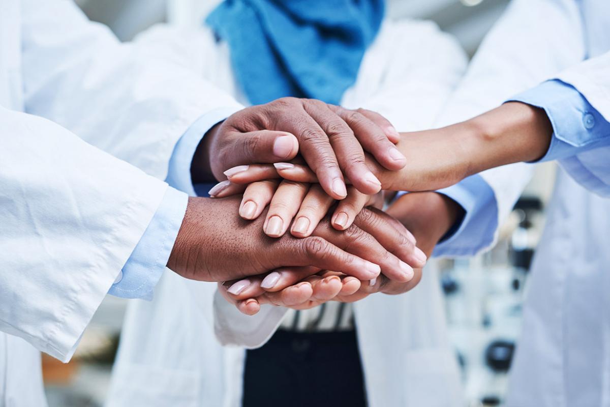 Close up of diverse group of health professionals' hands stacked on top of each other