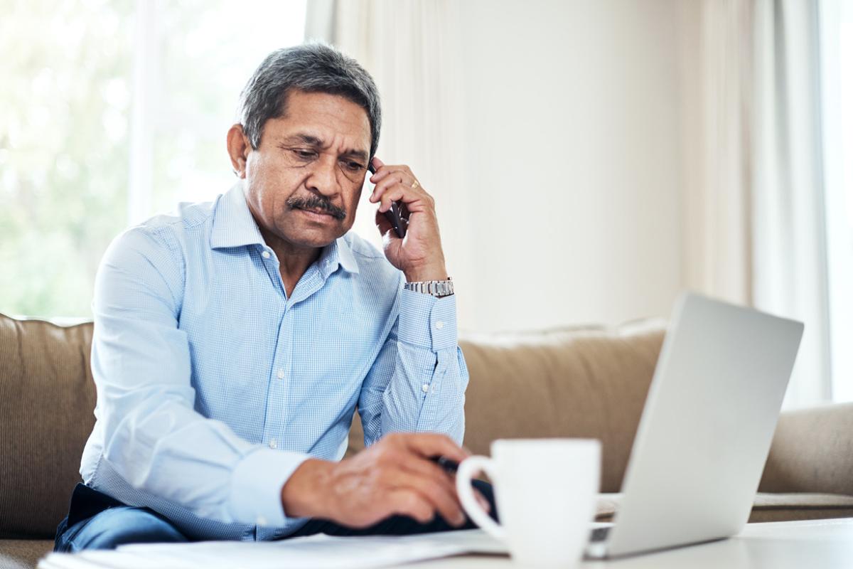Person on a phone in front of a laptop