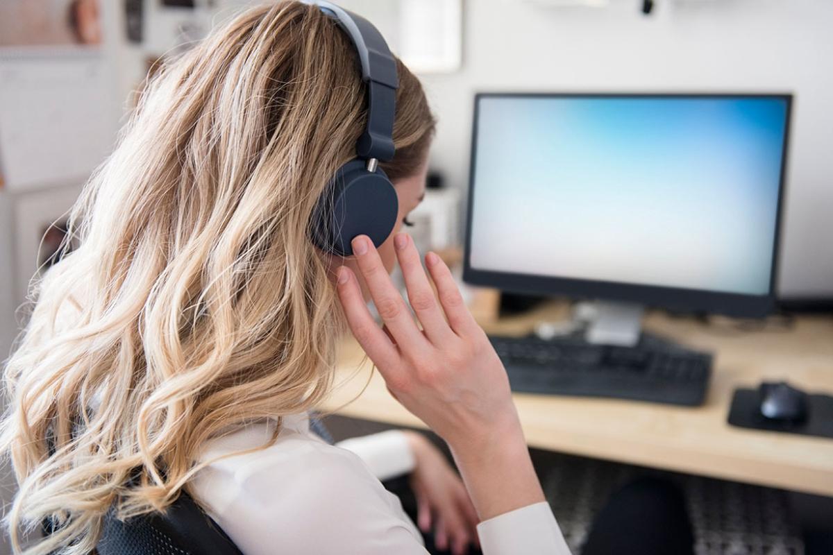 Person wearing a headset sitting in front of a computer