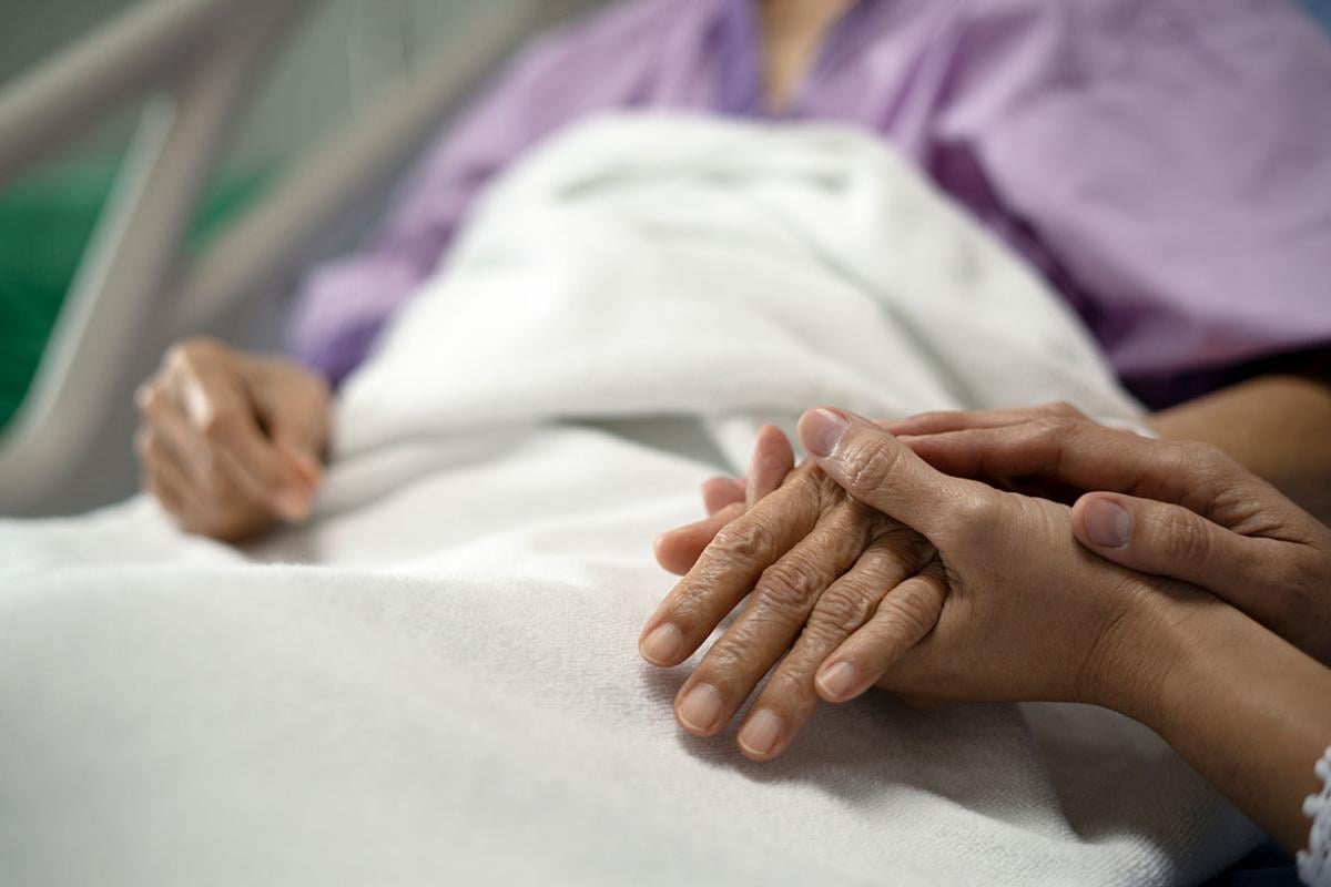 Person holding a patient's hand