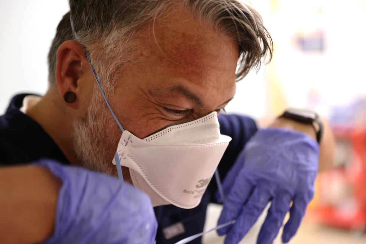 Health care worker putting on PPE