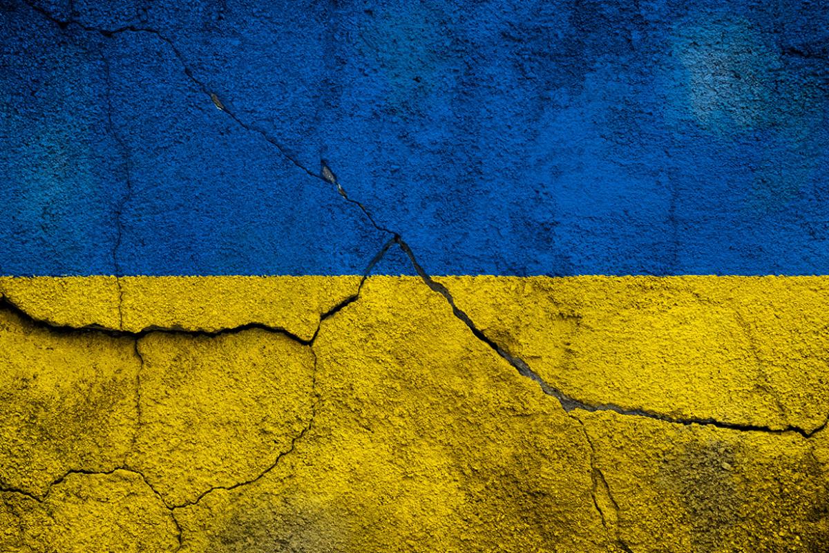 Ukrainian flag painted on concrete wall with cracks
