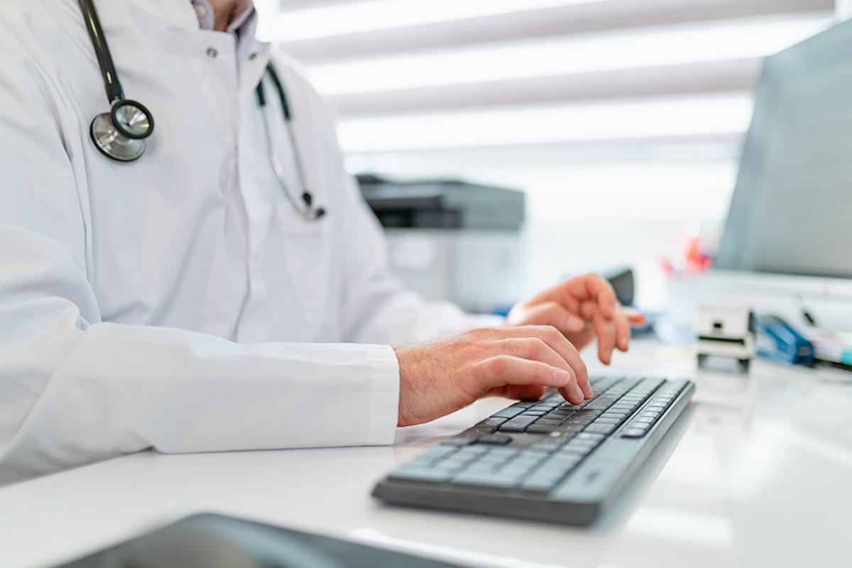  Physician typing on computer keyboard