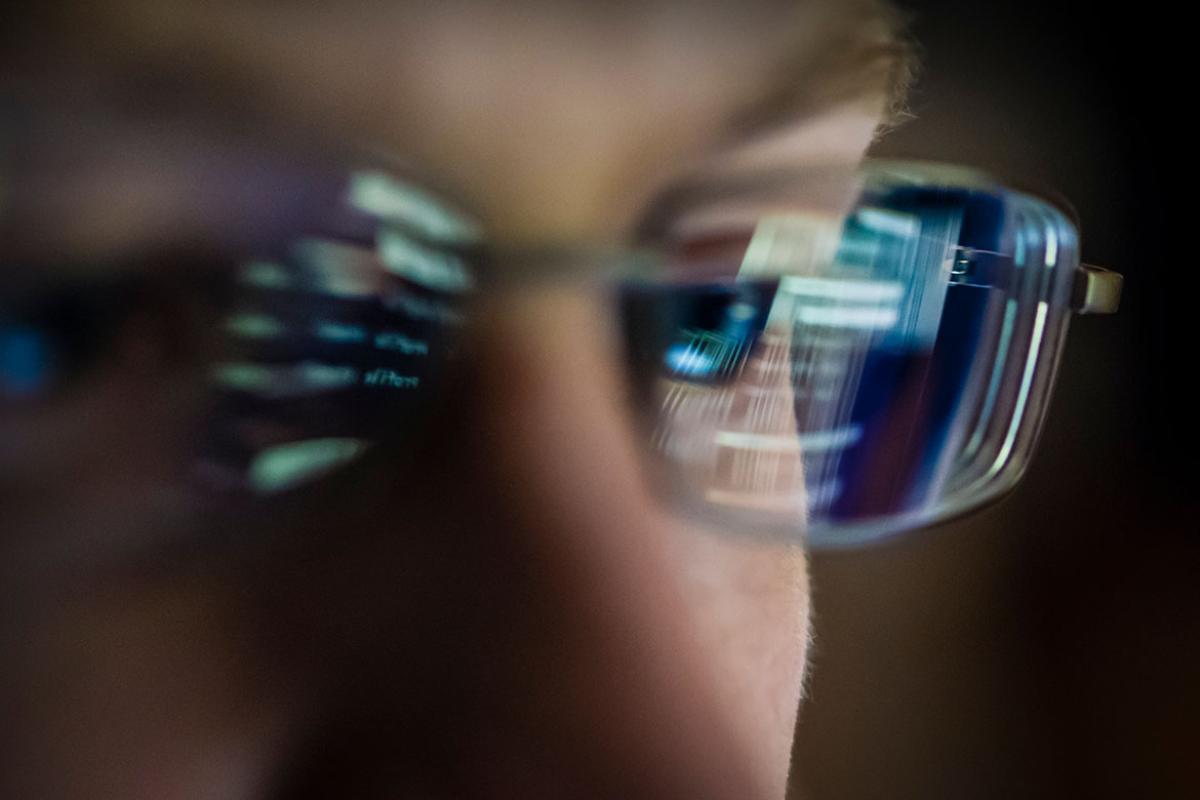 Computer screen reflected in a person's glasses