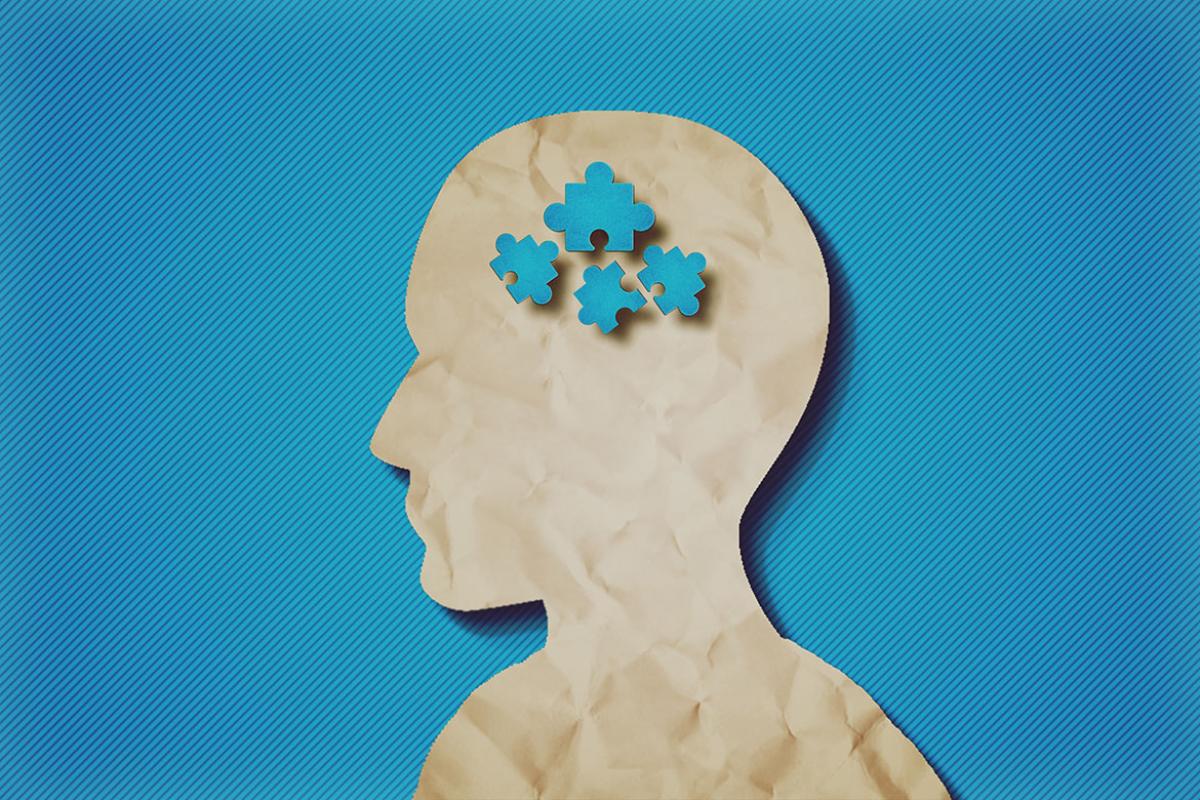Paper profile of a human head with puzzle pieces