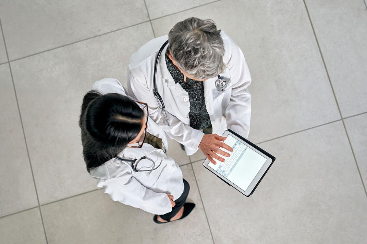 Overhead view of two physicians looking at a tablet