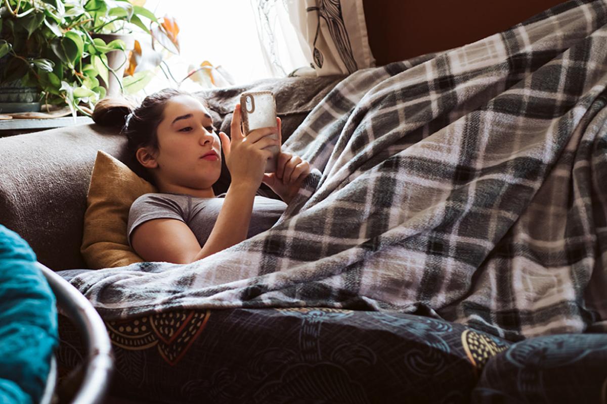 Teenager on couch looking at smartphone