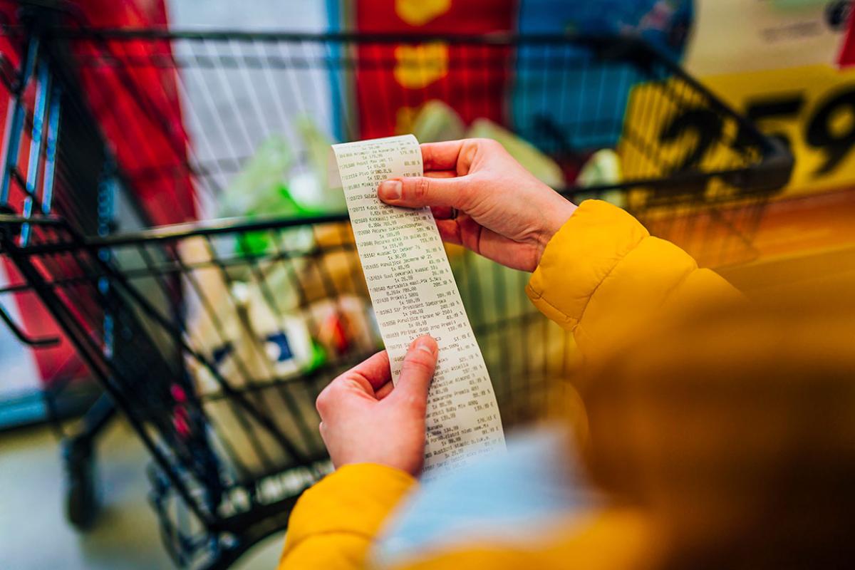 Person holding long receipt at the grocery store