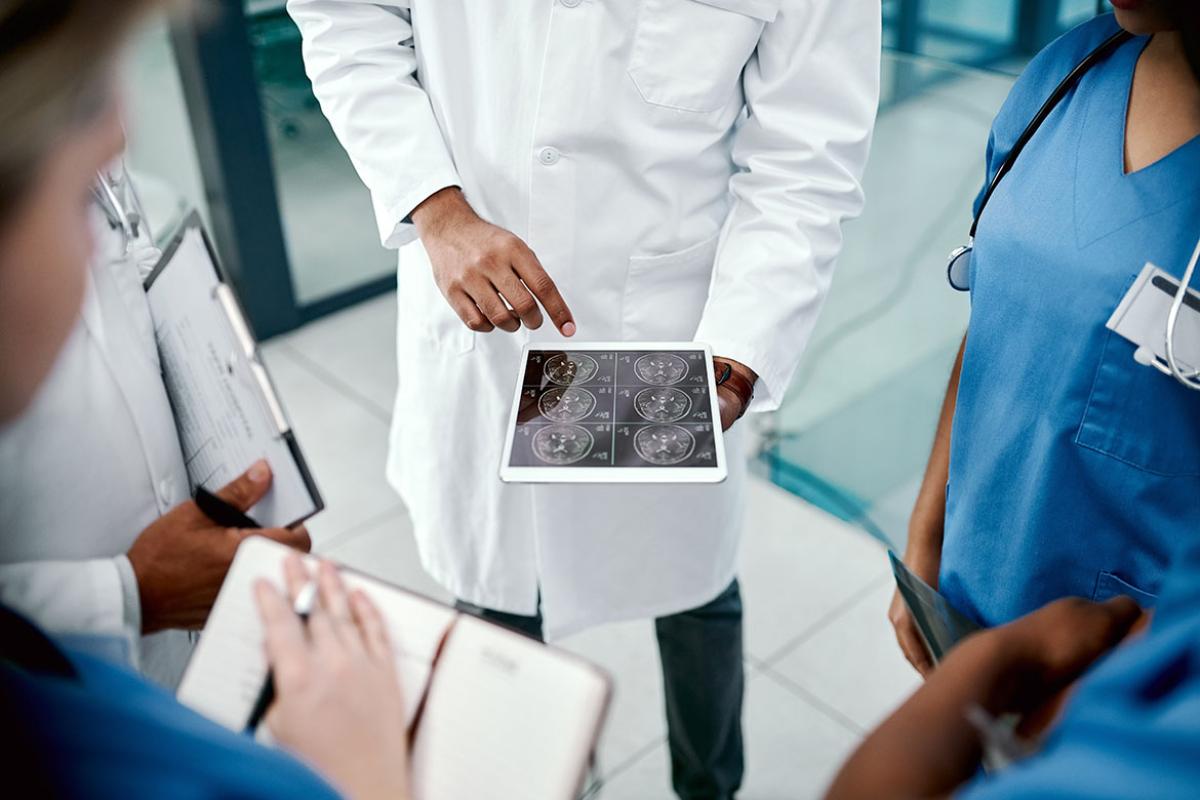 Group of health care professionals looking at a tablet