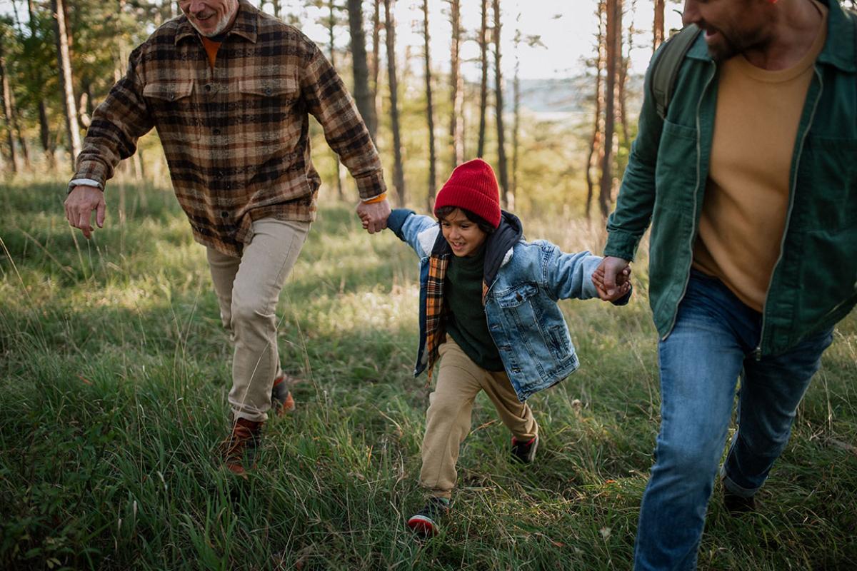 Two adults walking with a child in between.