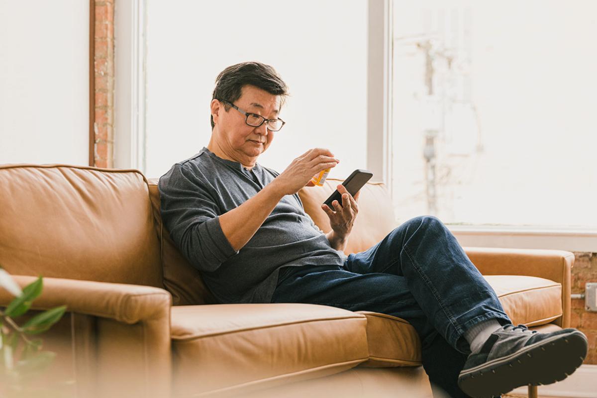 Person on couch looking at prescription label