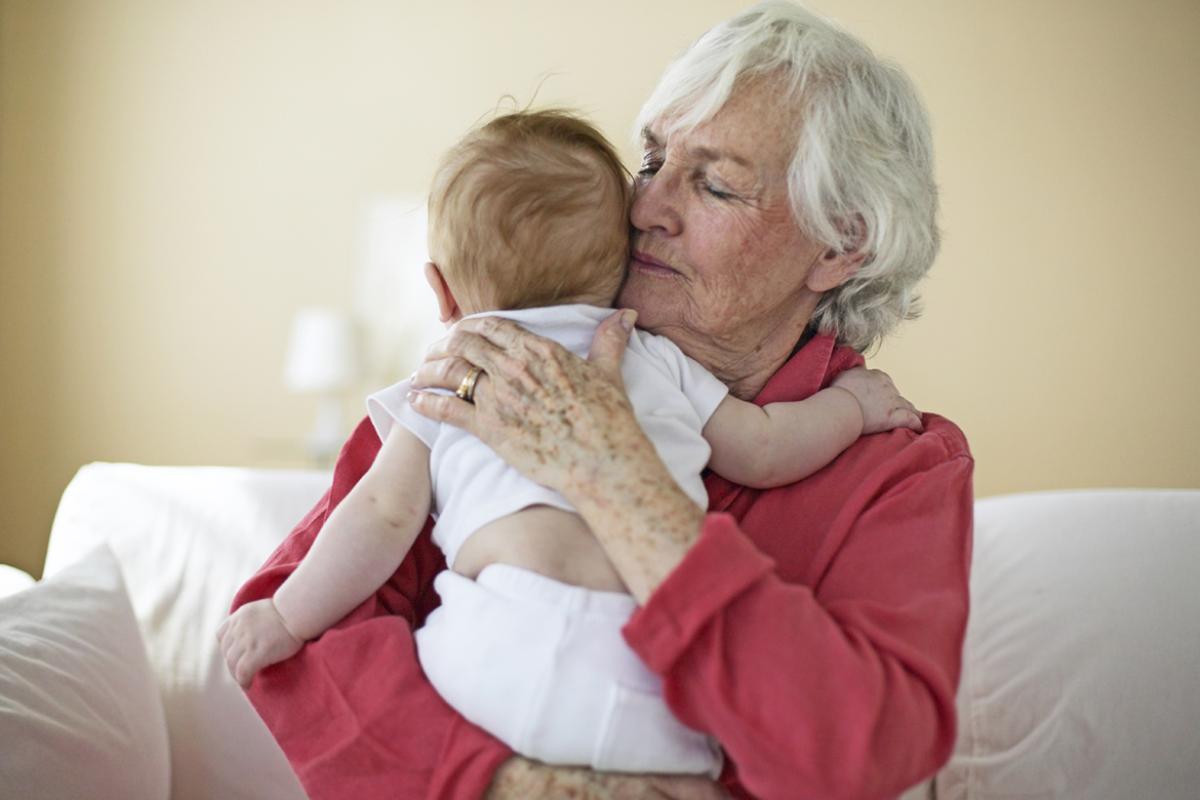 Elderly person holding a baby