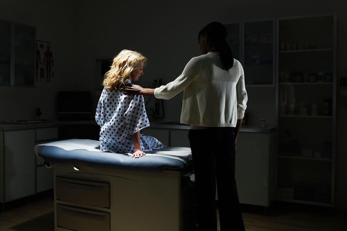 Health care worker and patient in a dimly lit room