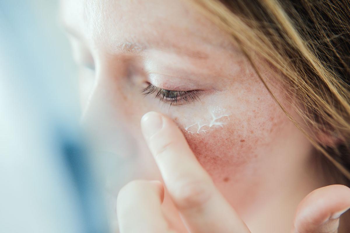 Person's finger touching dry skin on their face