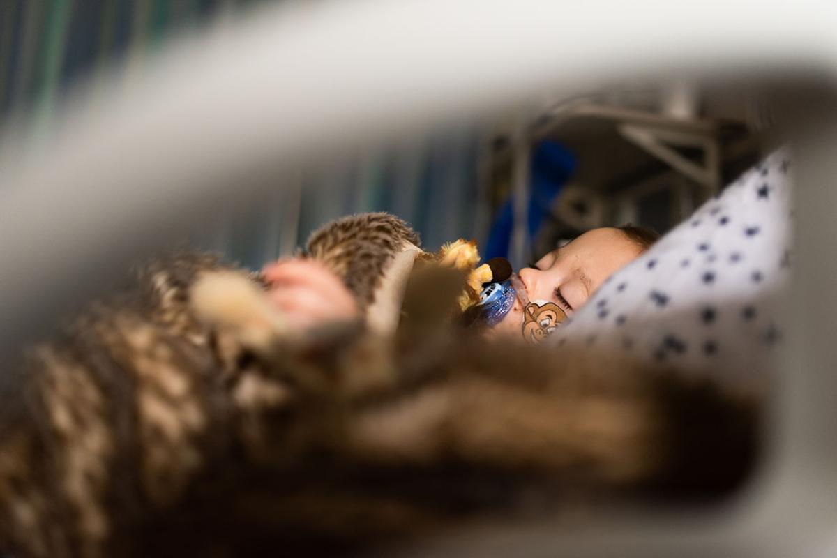Toddler in hospital pediatric intensive care unit