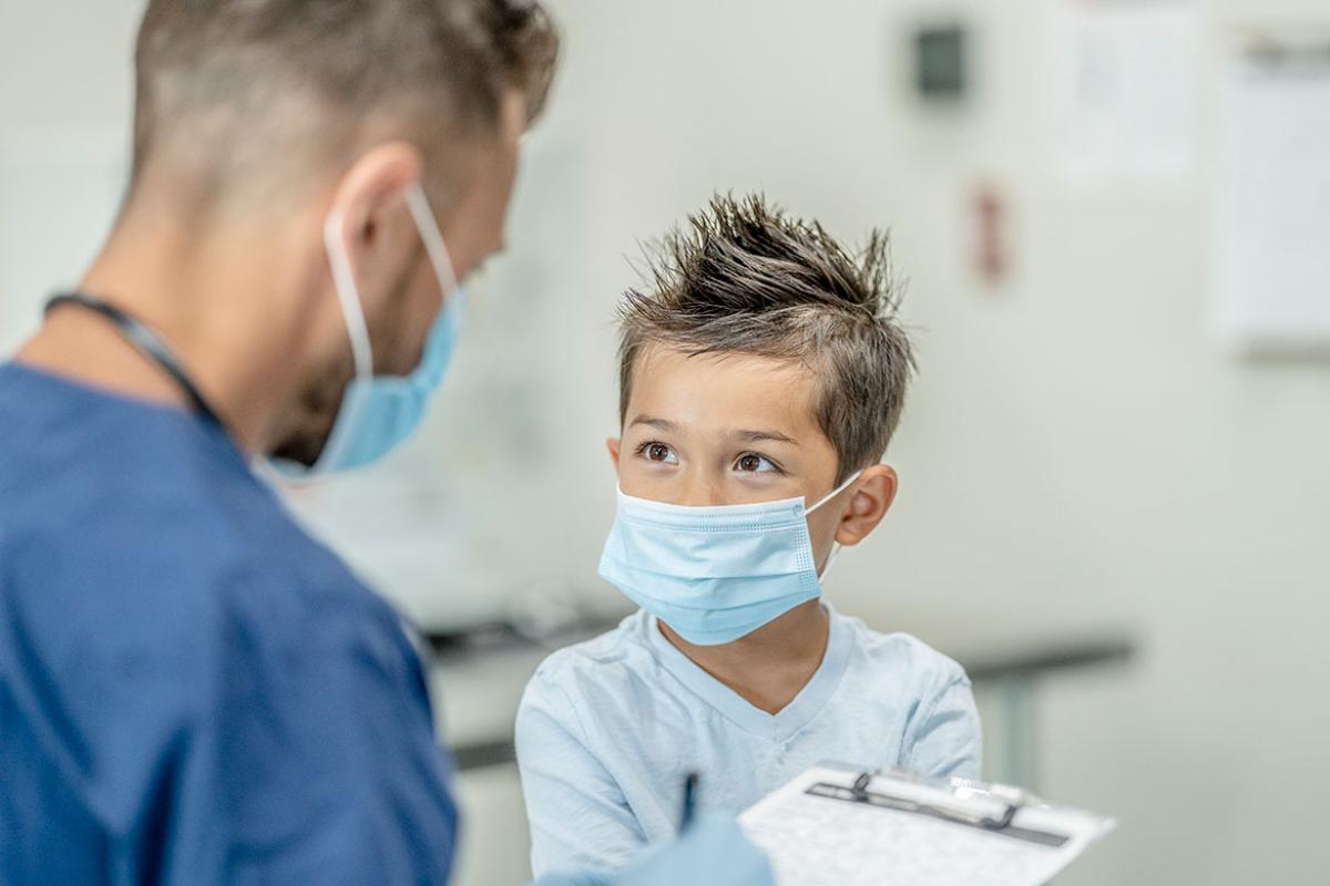 Young masked patient at an appointment with a health care worker