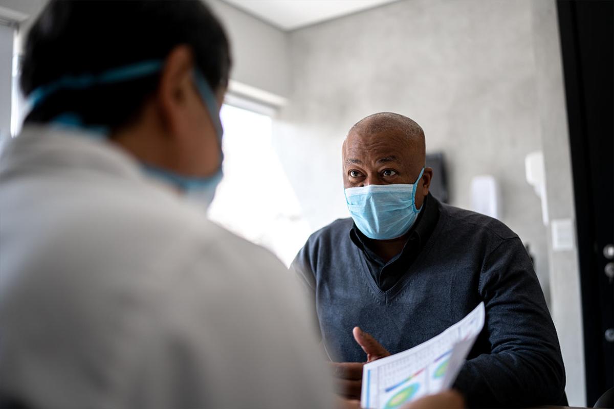 Masked patient speaking with physician