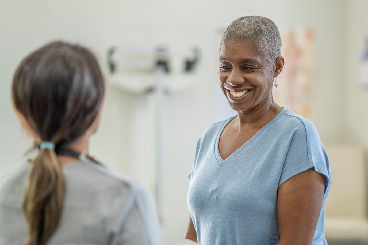 Smiling patient in conversation with health care worker