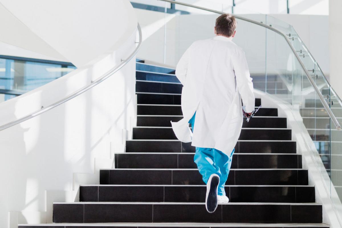 Health care worker walking up staircase