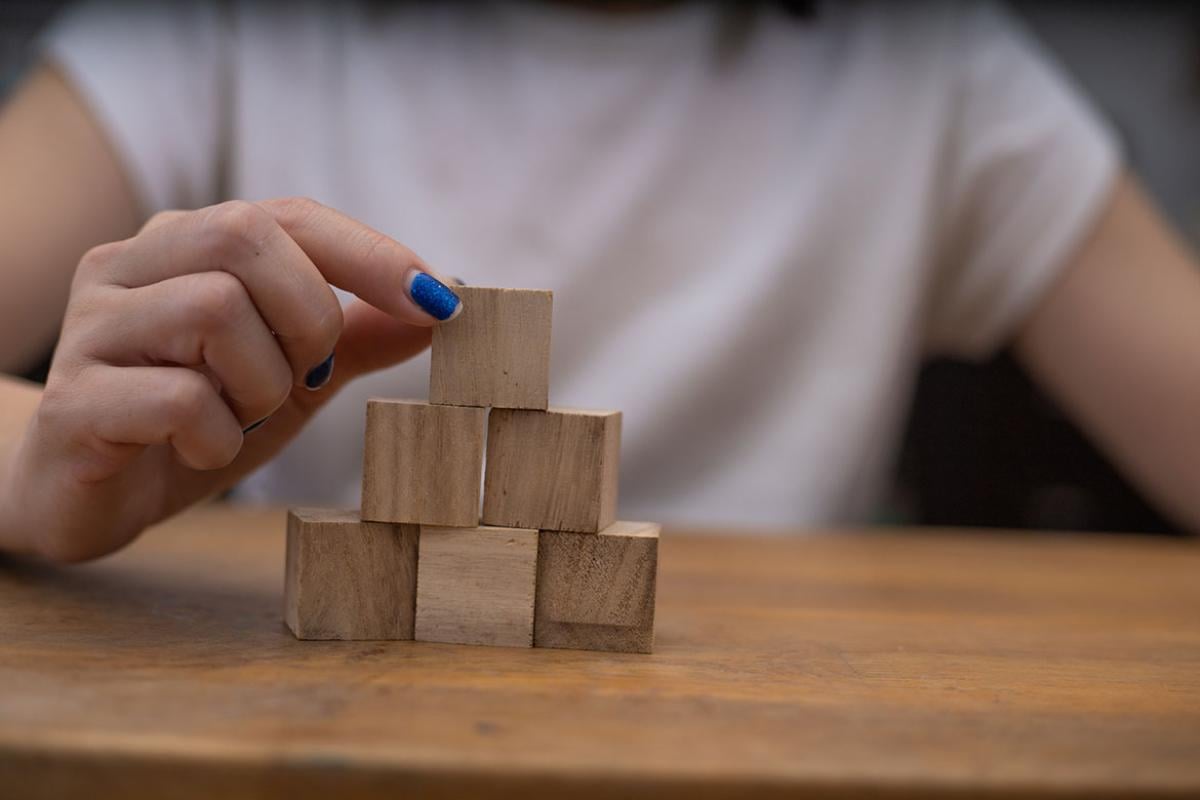 Person stacking blocks on table