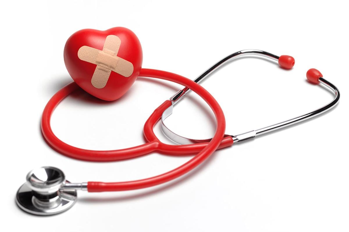 Stethoscope surrounding a foam heart with a bandage on it