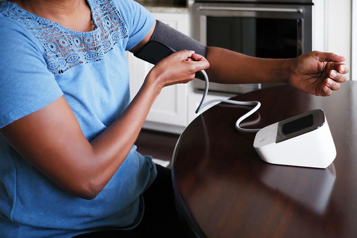 Person adjusts cuff on upper arm blood pressure monitor 