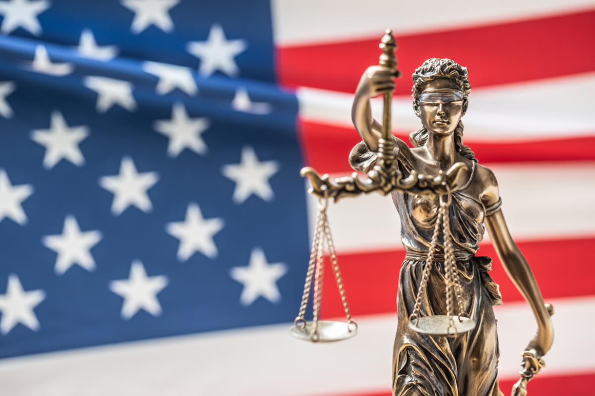 Lady Justice in front of a U.S. flag