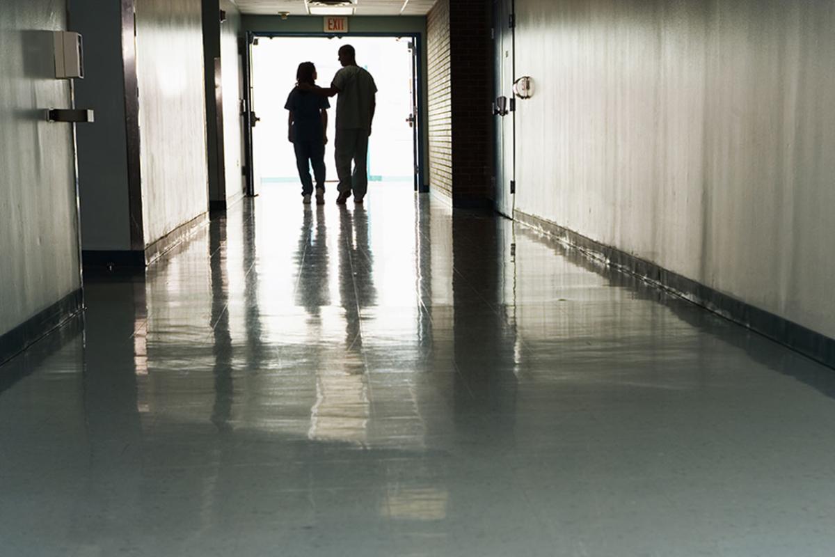 Two figures walking down a hallway