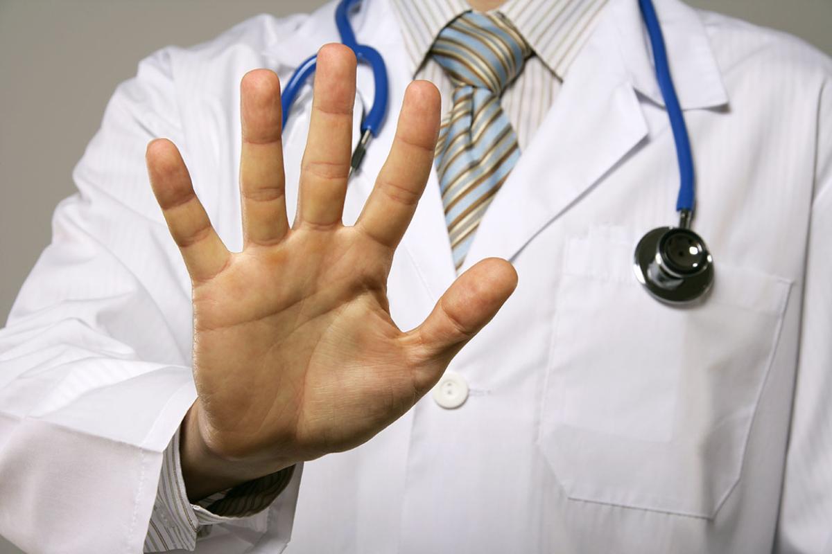 Male physician with his hand facing out in "stop" gesture