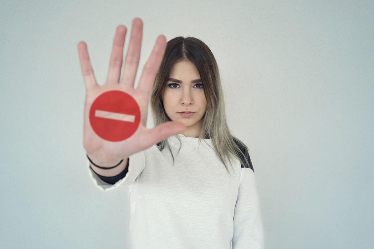 Young woman holding out her hand as a stop sign