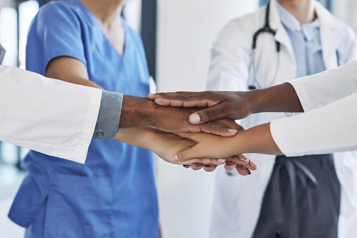Group of health care workers stacking hands