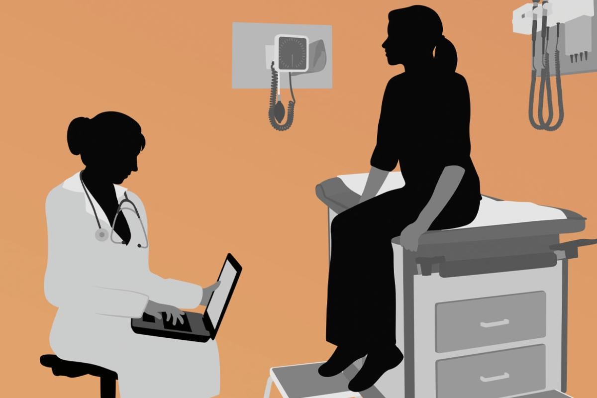 Silhouette of a doctor focusing on a laptop with the patient nearby