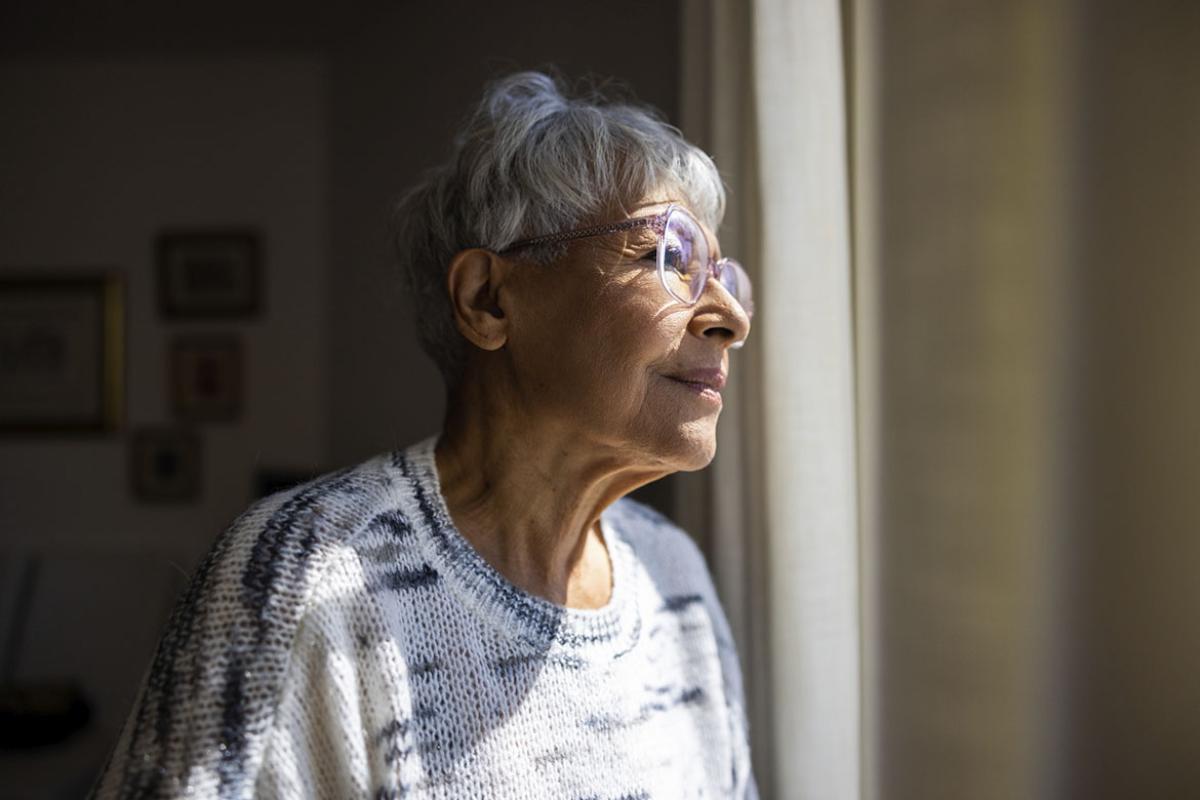 Elderly person looking out a window