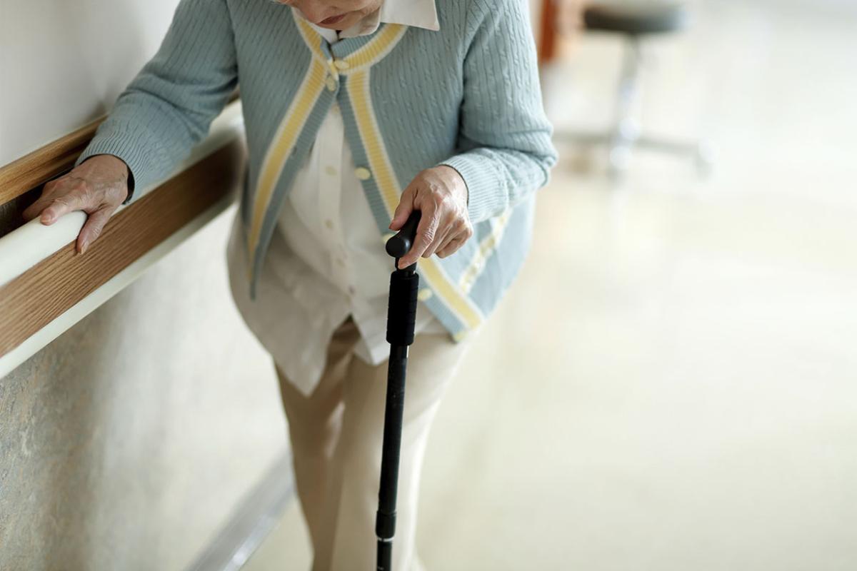 Person with a cane in a hallway