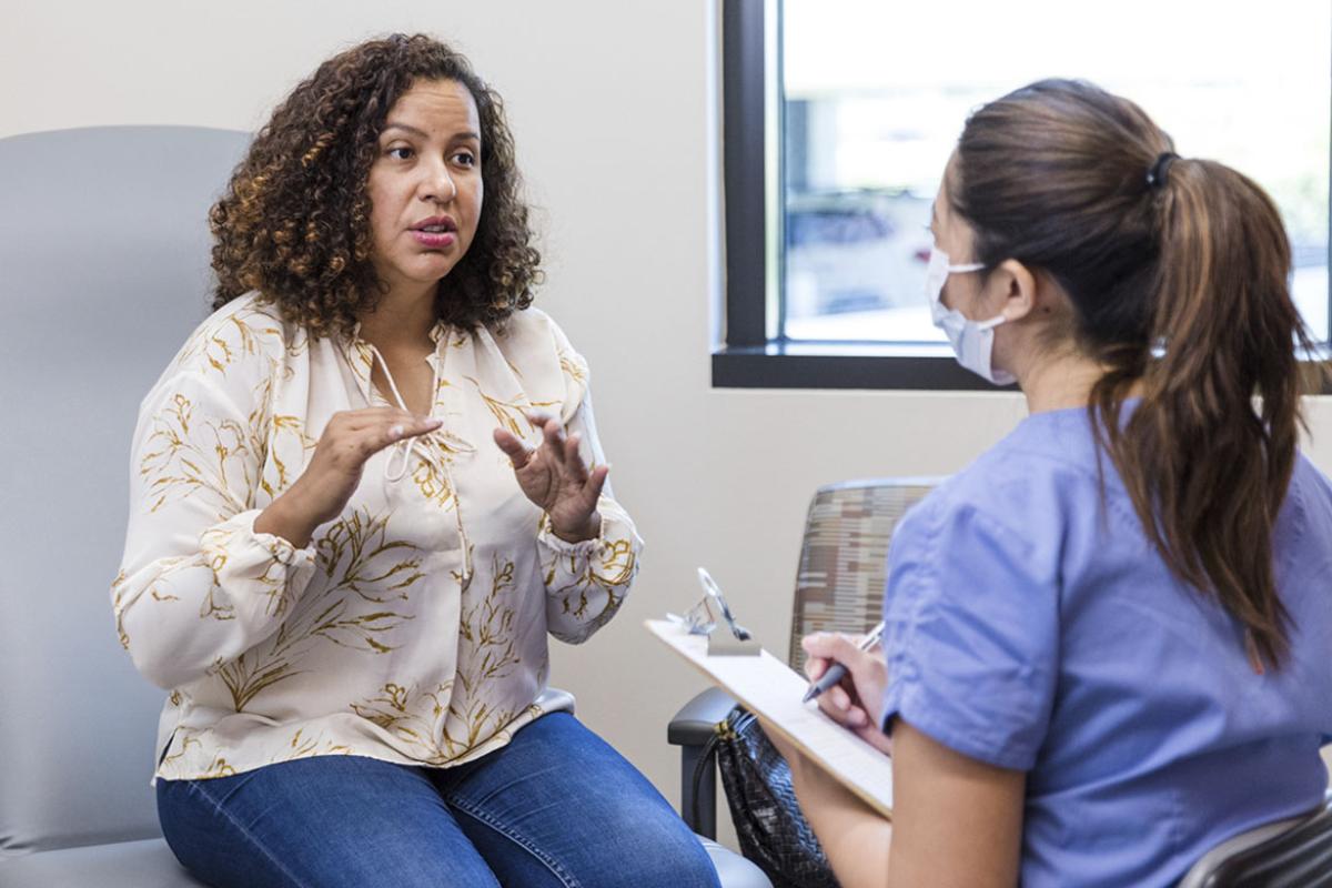 Patient speaking with health care worker in a doctor's office