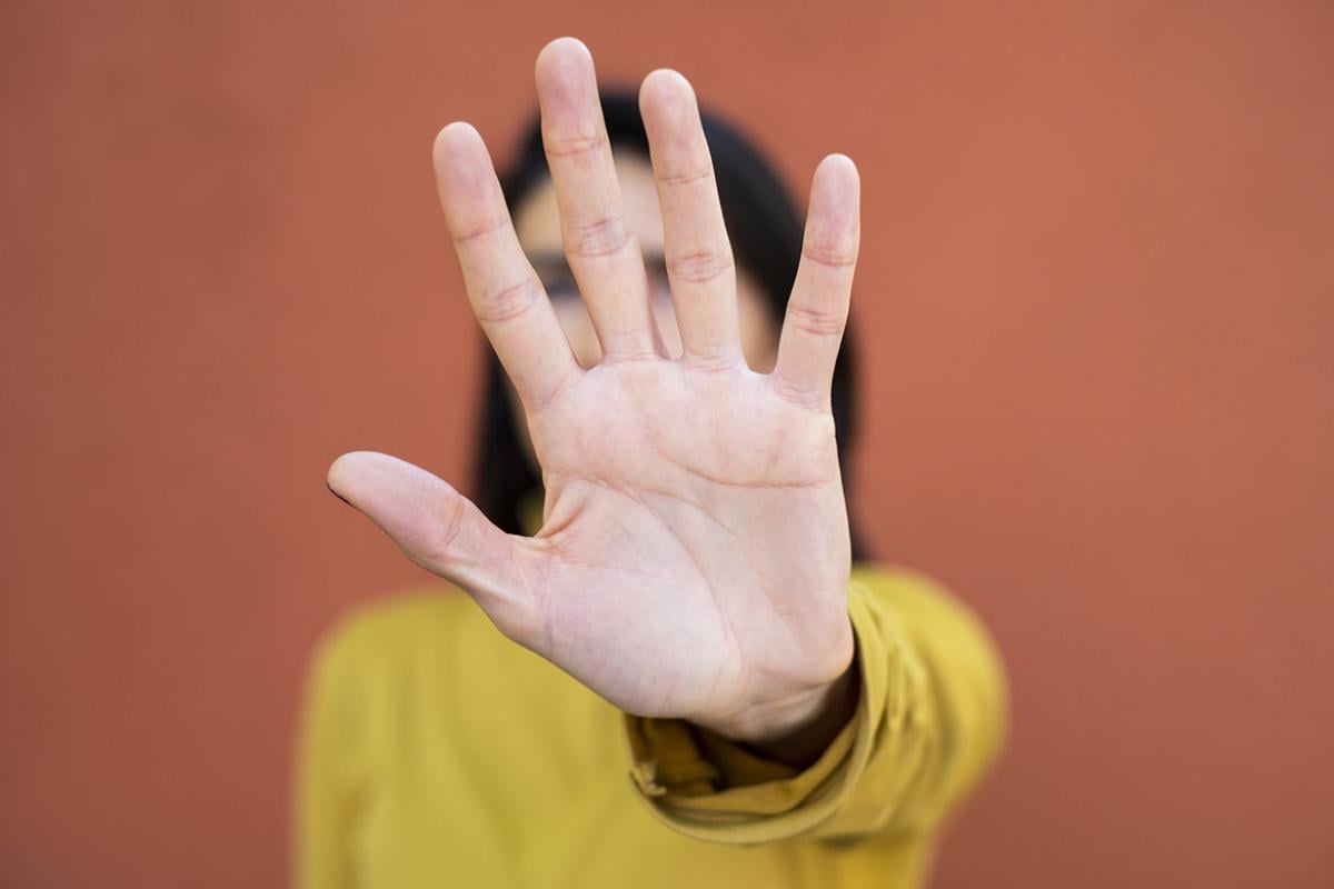 Person with raised hand in a stop gesture