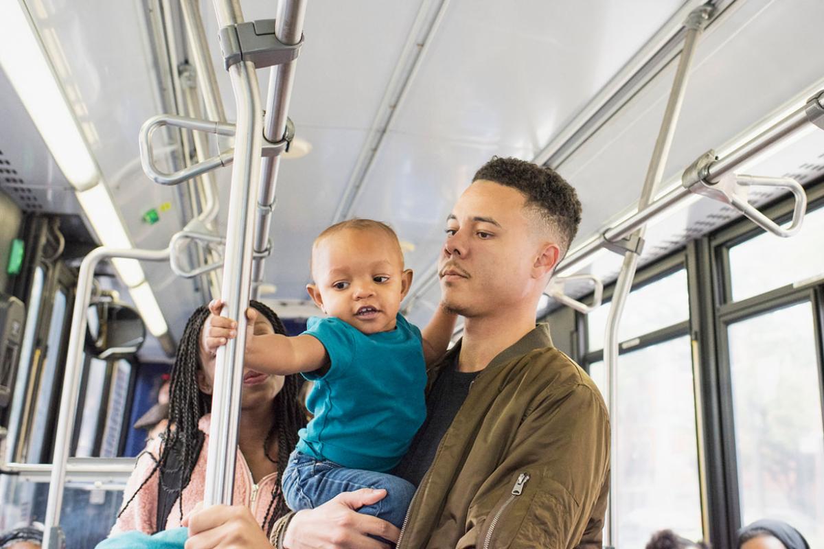 Young mother, father and infant riding city bus