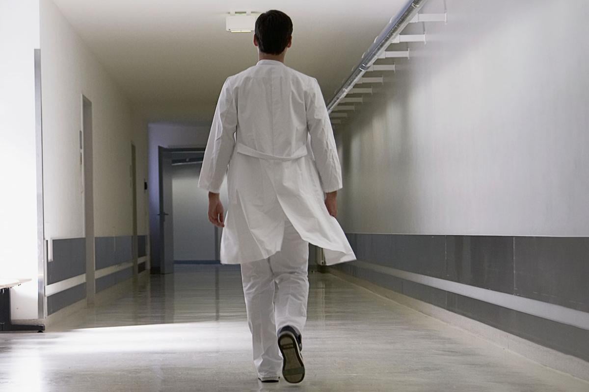 Physician walking down an empty hallway