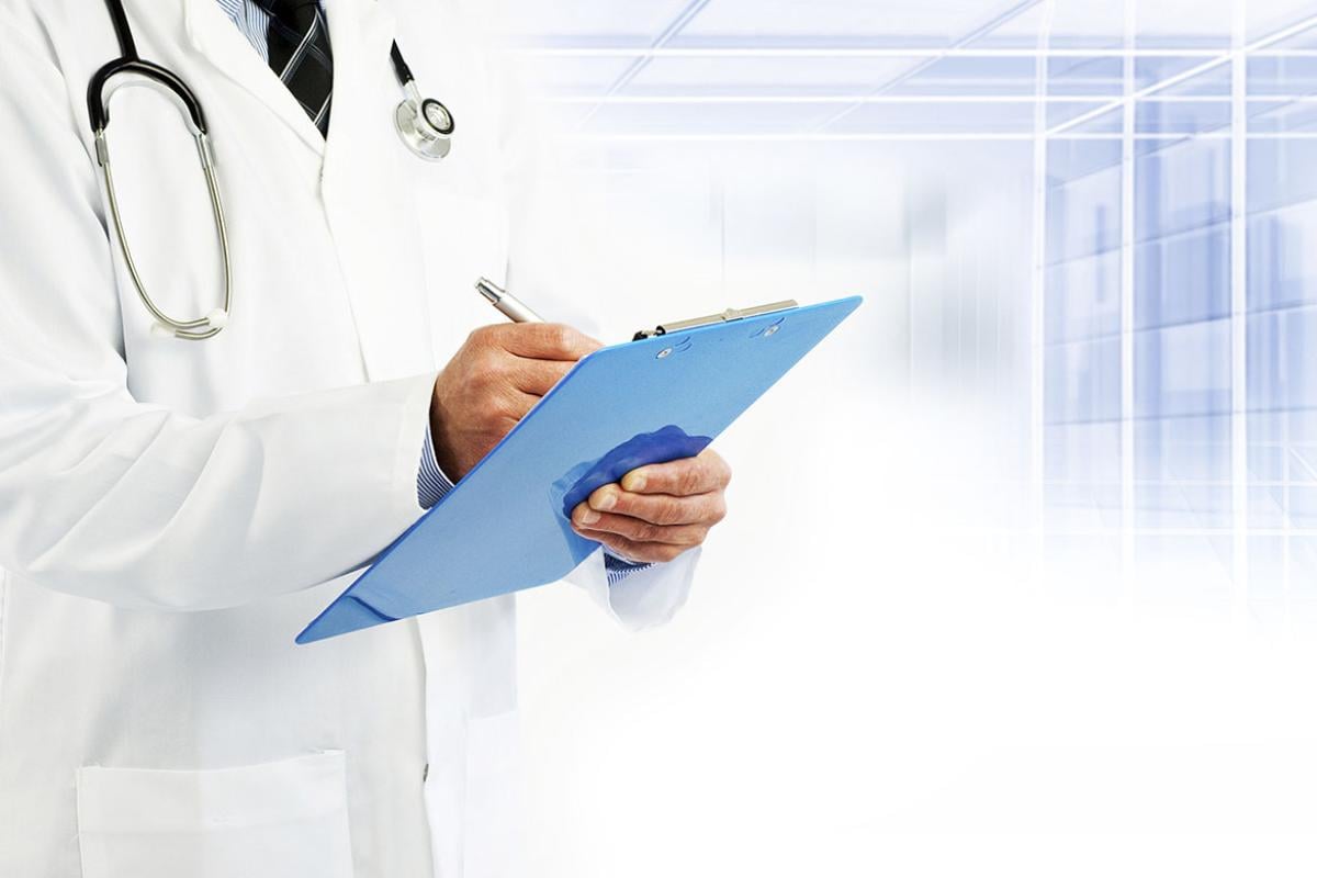 Physician writing on a clip board