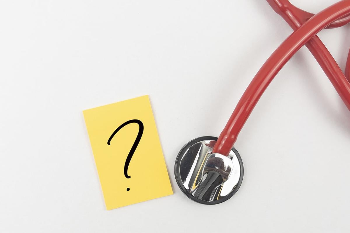Paper with a question mark next to a stethoscope