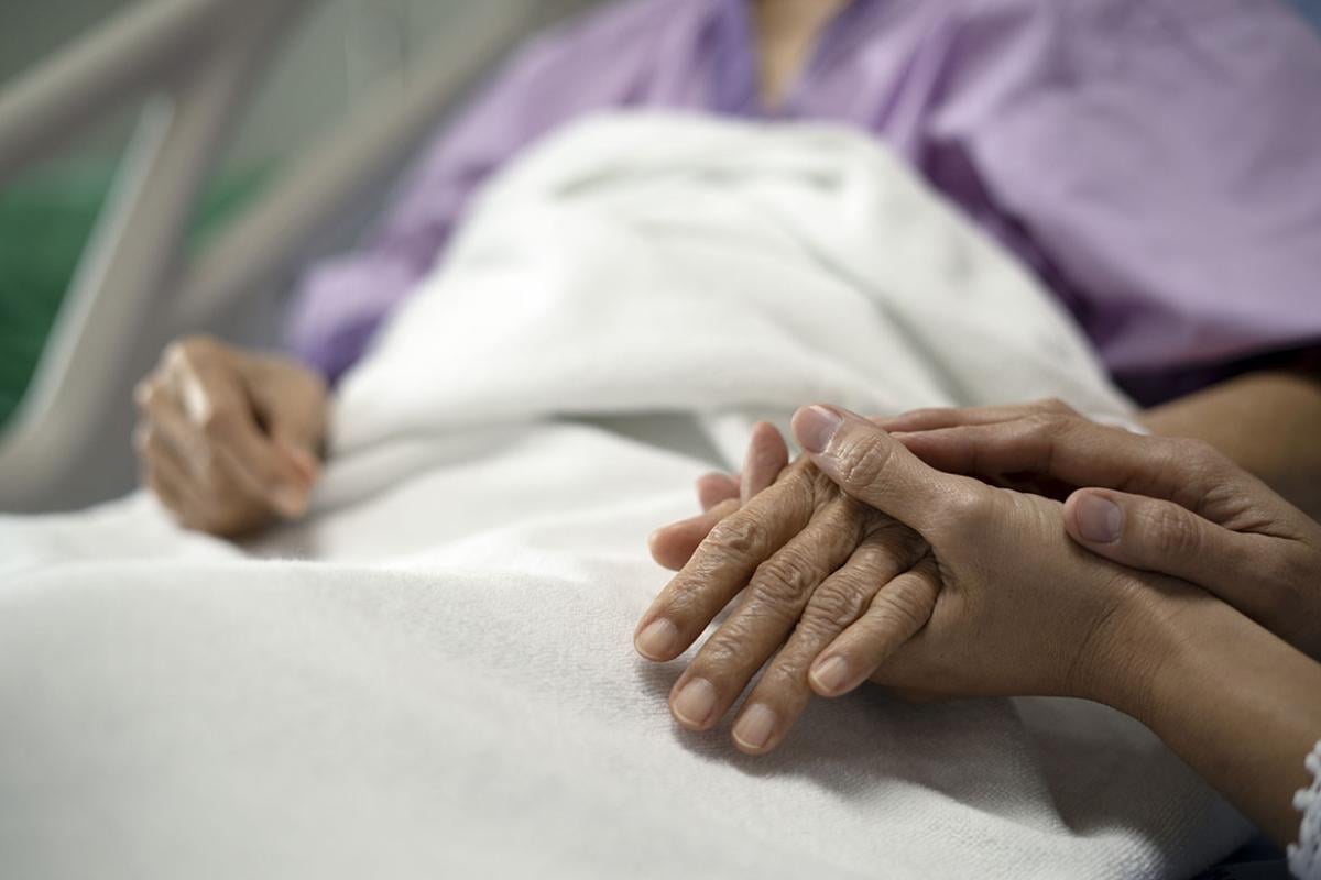 Pair of hands holding a hospital patient's hand