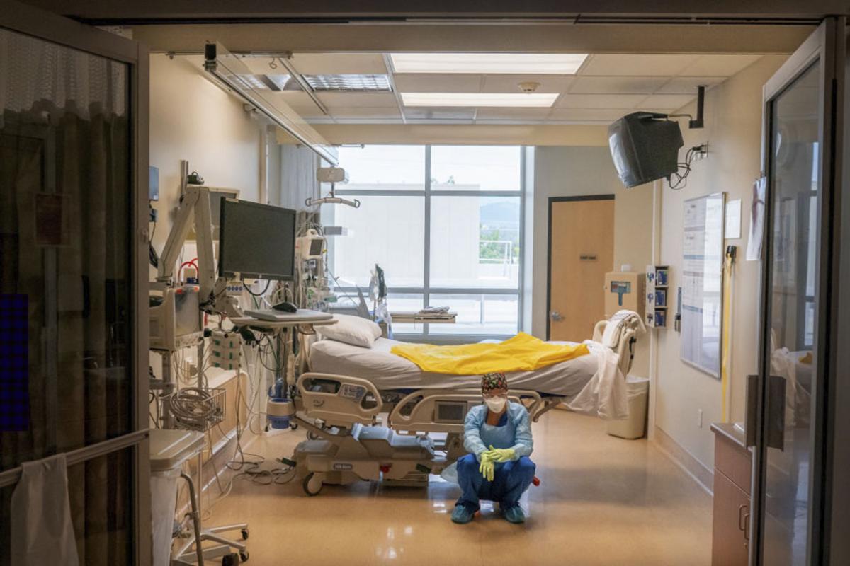 A nurse waits in an empty hospital room