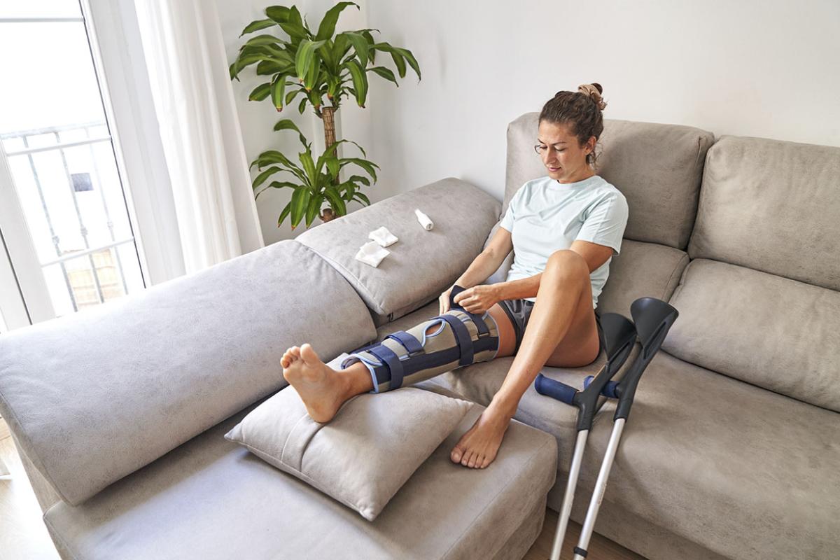 Person sitting on couch opening their knee splint