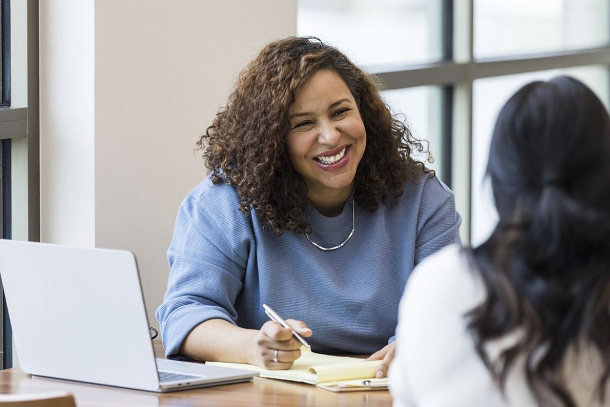 Businesswoman smiles encouragingly at coworker
