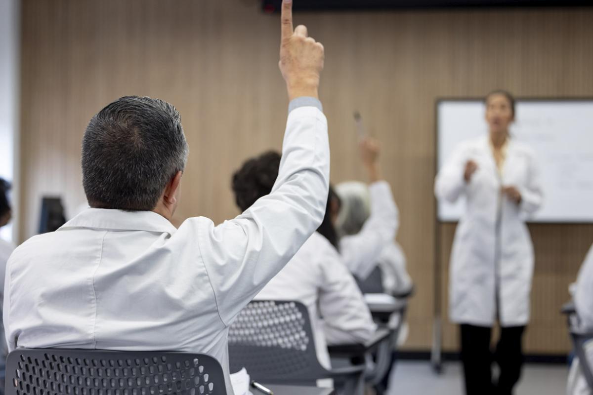Doctor raising hand to ask a question in a seminar
