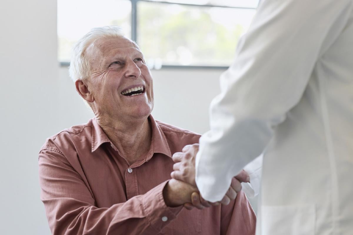 Smiling patient shakes doctor's hand