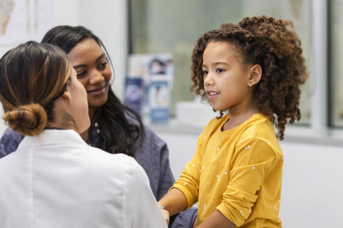 Young patient in a doctor's appointment while smiling parent looks on