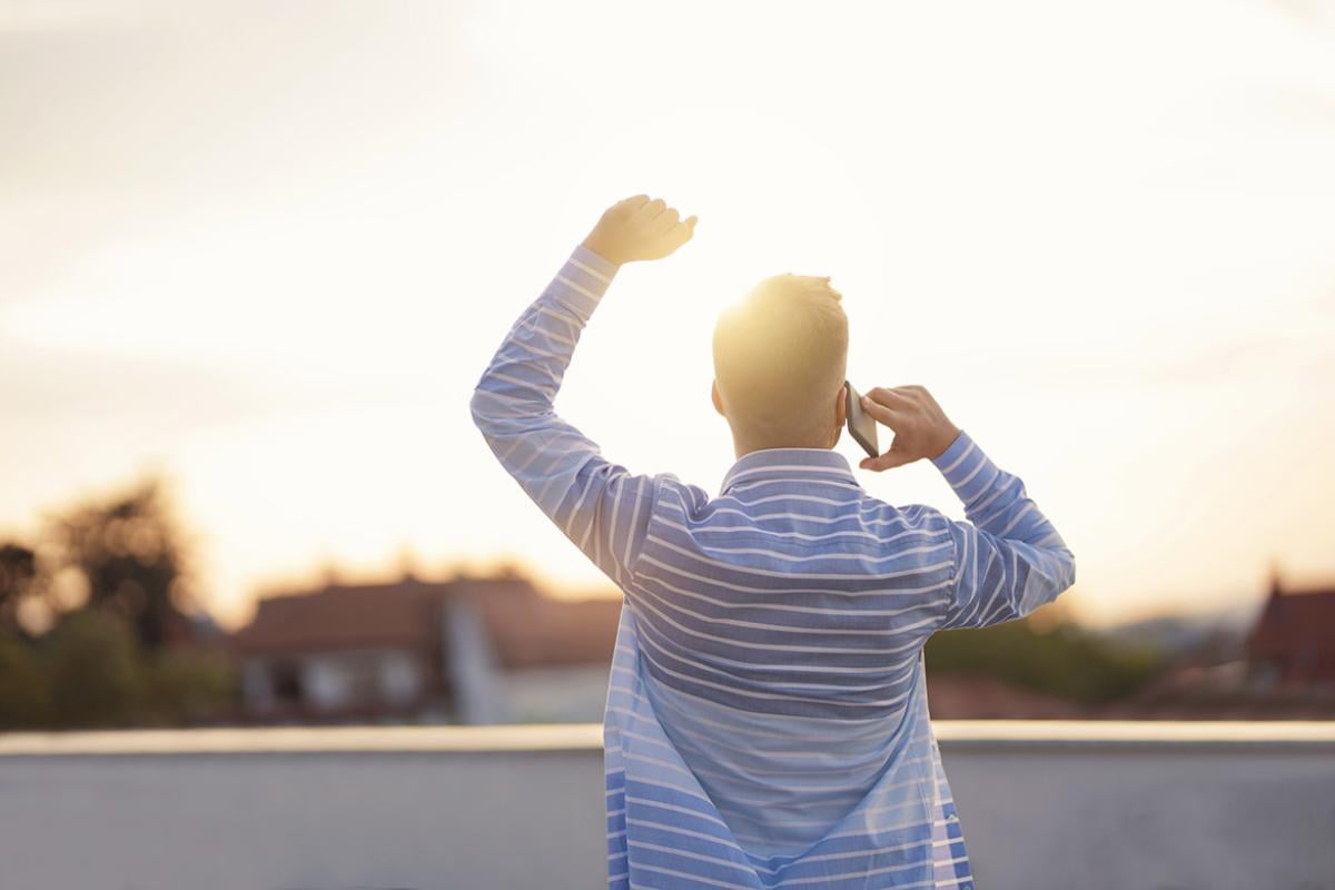 Man talking on a mobile phone and raising an arm